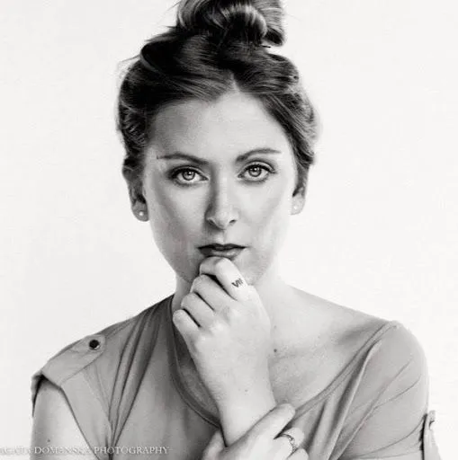 A black and white photo of a woman with her hand on her chin