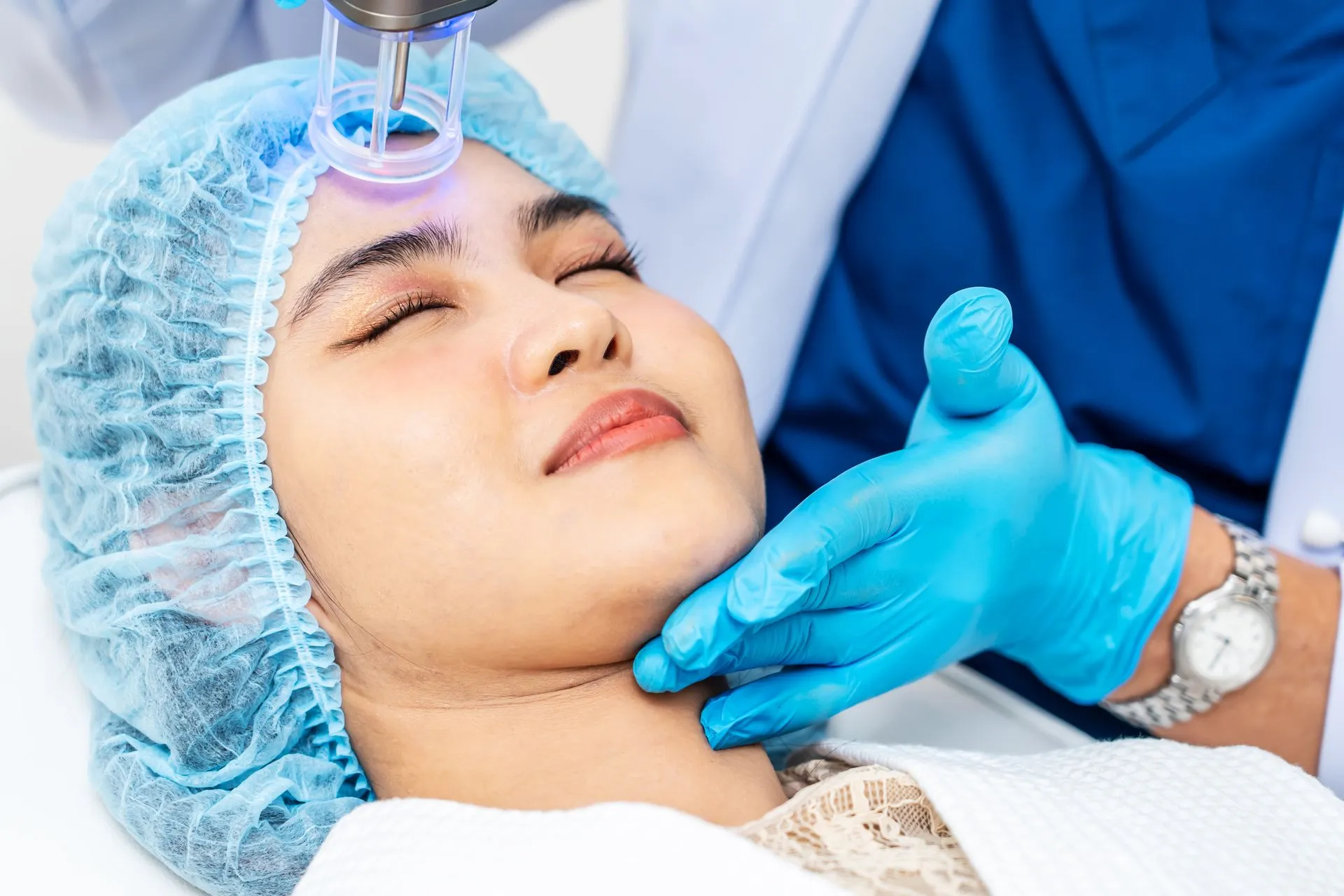 A woman is getting a laser treatment on her face.